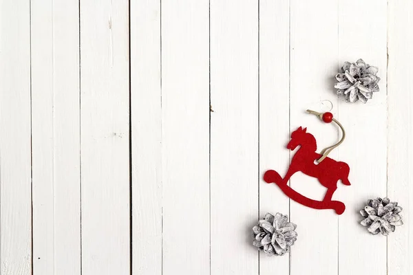 Christmas holiday background with toy horse and snow painted pin