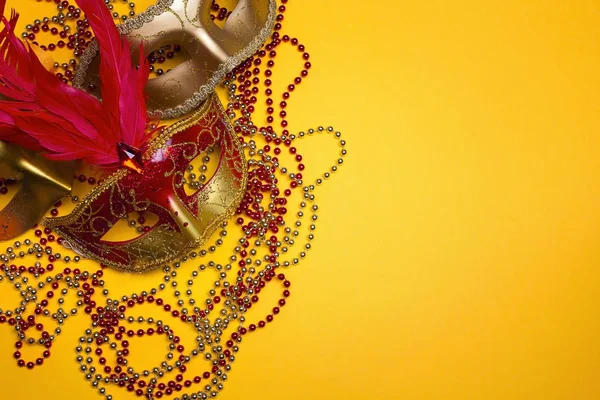 Karnevalové masky a korálky s kopií prostor na žlutém podkladu. — Stock fotografie