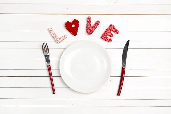 Älskar dukningen med gaffel, kniv och hjärta på en vit trä — Stockfoto