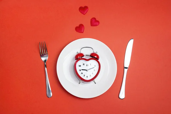 Festive table setting with cutlery and heart-shaped alarm clock