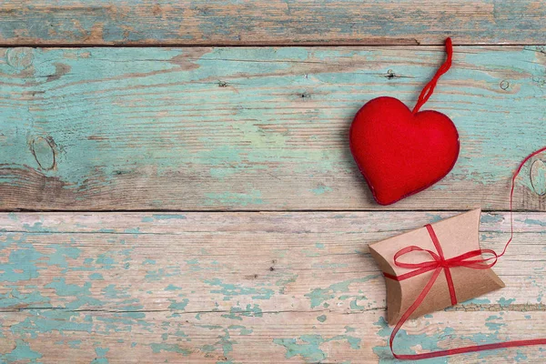 Confezione regalo con cuore su vecchio sfondo in legno turchese. Spazio per — Foto Stock