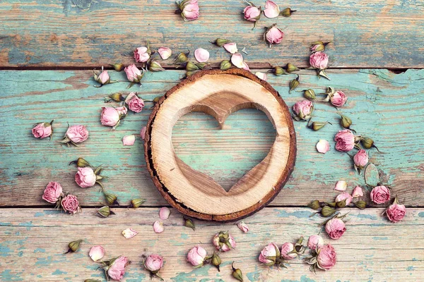 Houten hart met gedroogde roze bloemen op de turquoise oude houten — Stockfoto