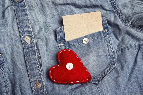 Cartão de papel vazio no bolso de camisa jeans e coração vermelho. Copiar sp — Fotografia de Stock