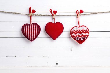 Clothespins kırmızı kalpler Beyaz ahşap arka plan asılı. SP