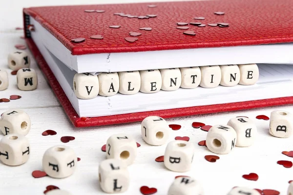 Palabra de San Valentín escrita en bloques de madera en un cuaderno en blanco — Foto de Stock