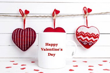 Tebrikler ve dekoratif kırmızı kalpler ile beyaz kahve kupa.