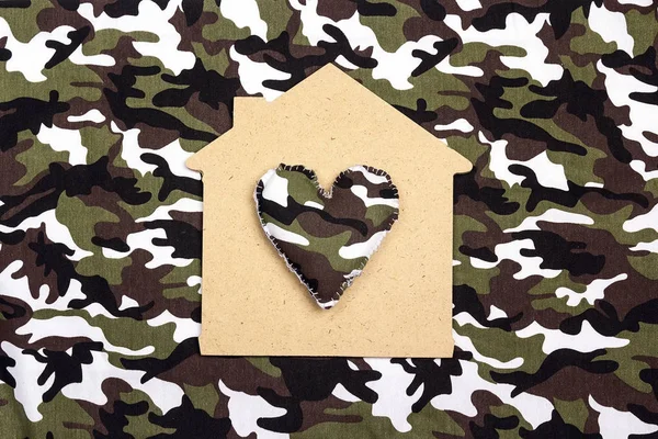 Symbool van een huis met een hart op camouflage achtergrond. — Stockfoto