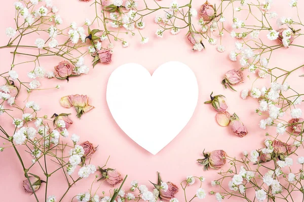 Heart-card  with small delicate white flowers and roses on pink