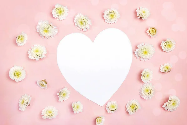 Heart-card with small chrysanthemum flowers on pink background.