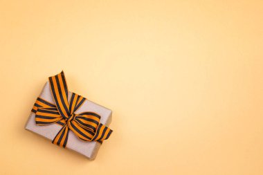 Gift box with st george ribbons on the yellow background. Space  clipart