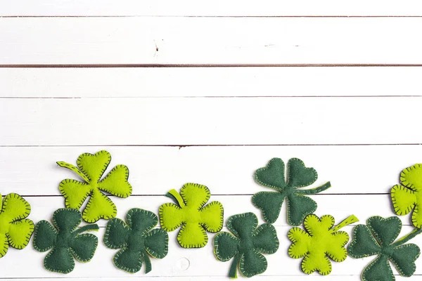 Okraji plstěný čtyři - leaf clover na bílém pozadí dřevěná. Štěstí — Stock fotografie