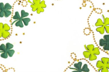 Frame of felt four-leaf clover and golden beads on white backgro clipart
