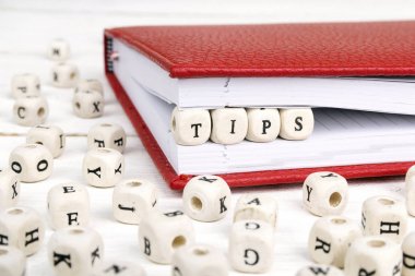 Ahşap bloklar halinde kırmızı defter beyaz tahtaya yazılmış Word ipuçları