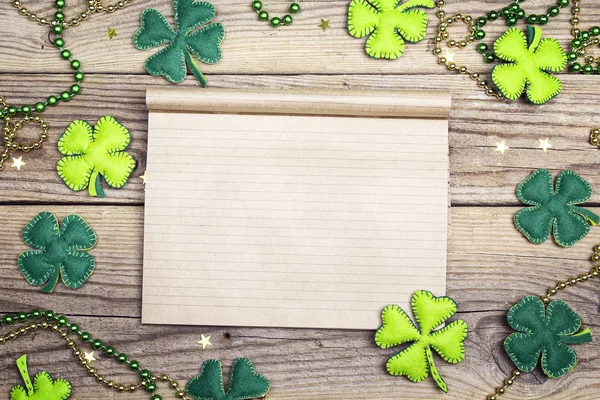 Blank notepad with clover leaves on wooden boards. Space for tex — Stock Photo, Image