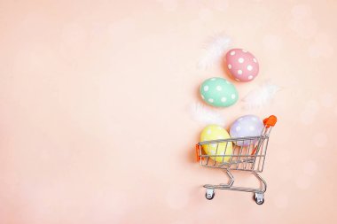 Pembe backgro üzerinde Paskalya yumurtaları ve kopya alanı ile alışveriş arabası