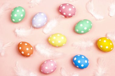 Tüylü pembe bir arka plan üzerinde renkli Paskalya yumurtaları.