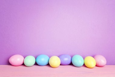 Mor arka plan üzerinde renkli Paskalya yumurtaları.