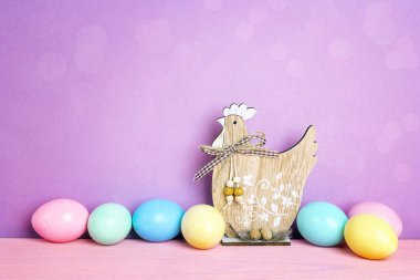 Mor zemin üzerine dekoratif tavuk ile renkli Paskalya yumurtaları. 