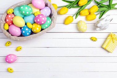 Sepet yumurta ve bir beyaz tahta tabl üzerinde Sarı laleler