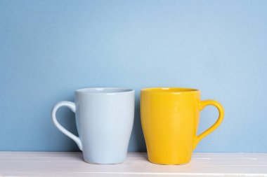 Mavi ve sarı kupalar kopya alanı ile mavi bir arka plan üzerinde.