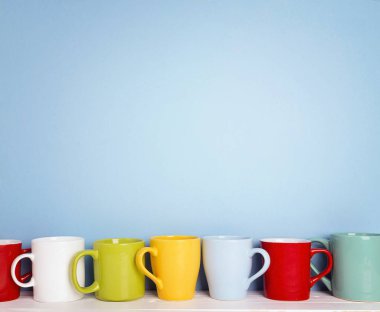 Kopya alanı ile mavi bir arka plan üzerinde renkli kupalar.