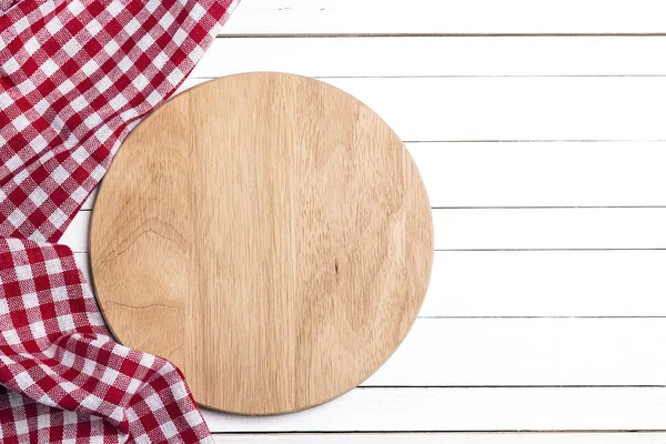 Cutting board with napkin on white wooden table. Copy space. — Stock Photo, Image