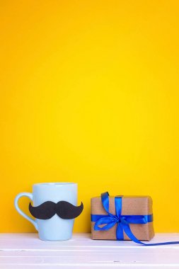 Bir bıyık ve Hediyelik kutu Sarı zemin üzerine mavi kupa. Kopya
