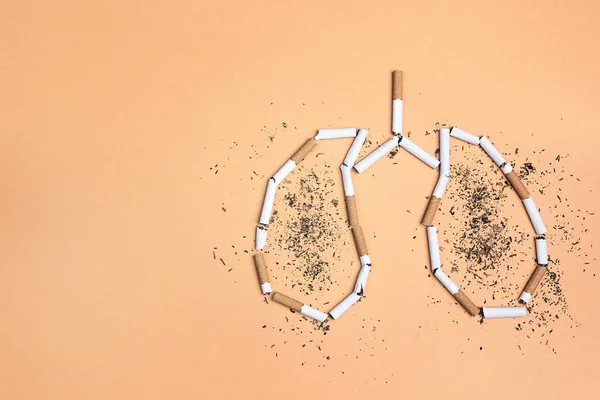 Cigarrillos rotos y tabaco en forma de pulmones en el bac amarillo — Foto de Stock