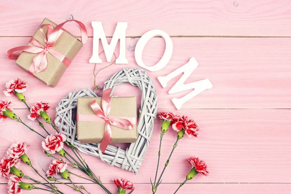 Muttertagshintergrund Mit Nelkenblumen Und Geschenkschachteln Auf Rosa Holztisch Ansicht Von — Stockfoto