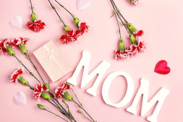 Mother's Day background with carnation flowers and gift box on p