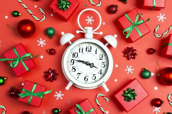 Christmas alarm clock with gift boxes and decorations on a red b — Stockfoto