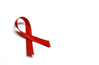 Beyaz arkaplanda AIDS farkındalığının sembolü olarak kırmızı kurdele 