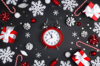 Siyah bir B üzerinde hediye kutuları ve süslemeleri olan şenlikli çalar saat.