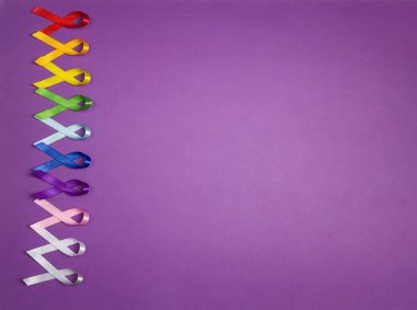 Mor arka planda renkli farkındalık kurdeleleri. Dünya Kanser Günü konsepti, 4 Şubat. Uzayı metin için kopyala. Sağlık ve Tıp Konsepti. 