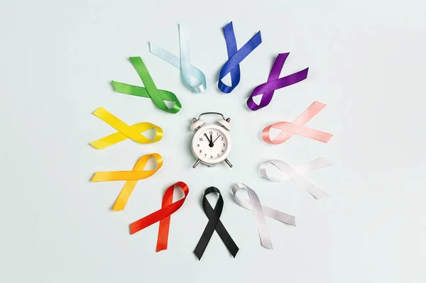 Circle of  colorful awareness ribbons with alarm clock on blue b — 스톡 사진