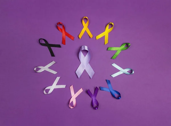 Circle of colorful awareness ribbons on purple background. World — 스톡 사진