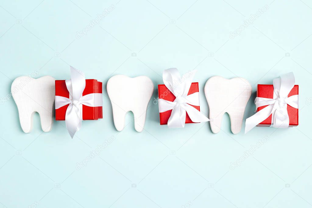 Teeth and gift boxes on a blue background. Happy Dentist's Day c