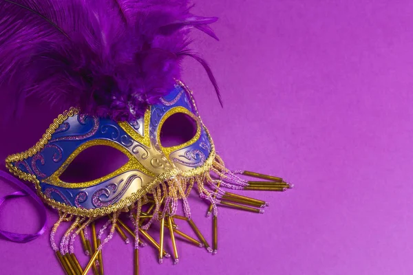 Máscara de carnaval con plumas púrpuras sobre fondo púrpura . — Foto de Stock