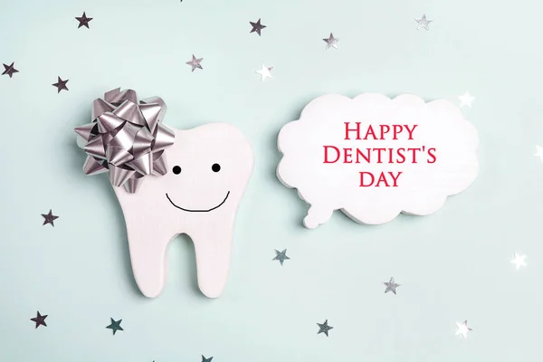 Dentist\'s Day greeting card with tooth and speech bubble on a bl