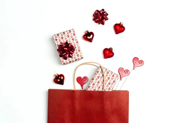 Red shopping bag with gifts and hearts on white background. — Stock Photo, Image
