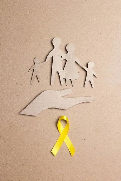 Kartonnen silhouet van een familie met geel bewustzijnslint op — Stockfoto