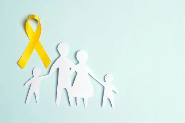 Papieren familie silhouet met geel bewustzijnslint op een blauwe b — Stockfoto