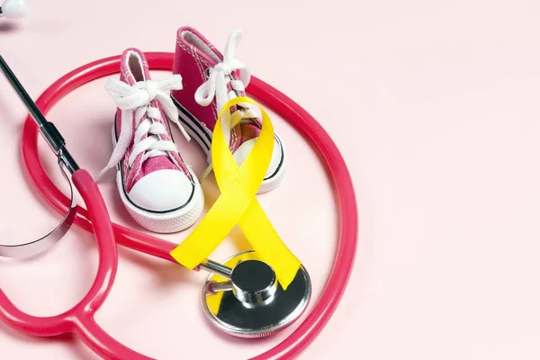 Conscientização do câncer infantil Golden Ribbon com tênis de bebê e — Fotografia de Stock