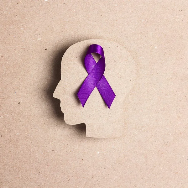 Purple awareness ribbon and head silhouette on a brown backgroun