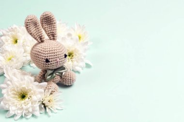 Kasımpatı çiçekli sevimli oyuncak tavşan ve mavi arka planda kopya alanı.