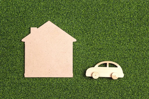 House and car symbol on green decorative lawn.  Ecology housing, eco home. Mortgage, construction and property investment.