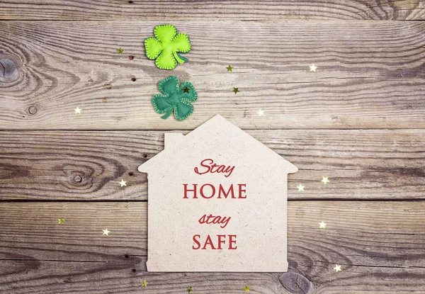 验尸官检疫海报上写着一句话呆在家里 注意安全 带有木制背景的四叶草的房子象征 — 图库照片