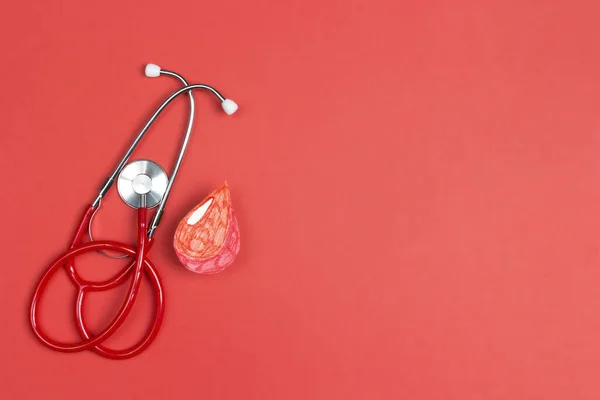コピースペースの赤い背景に聴診器と血滴のシンボル 世界ヘモフィリアまたは献血者の日 — ストック写真