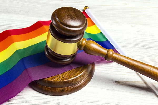 Tahta masadaki gökkuşağı LGBT bayrağı üzerinde Yargıç Tokmak. LGBT hakları, adalet ve hukuk eşitliği kavramı