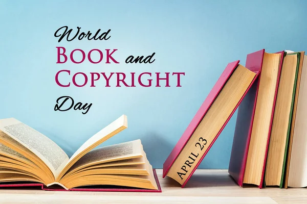 World book and copyright day, april 23. Poster with stack of books with open book on against a blue background.